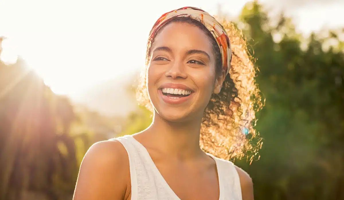 A confident woman with a dazzling, natural smile, representing the beautiful aesthetic results of porcelain veneers.