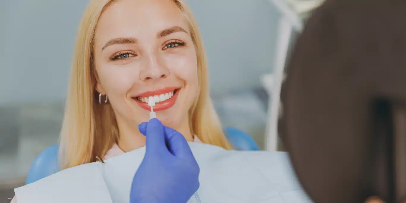 happy woman choose veneers enamel color compare teeth shade