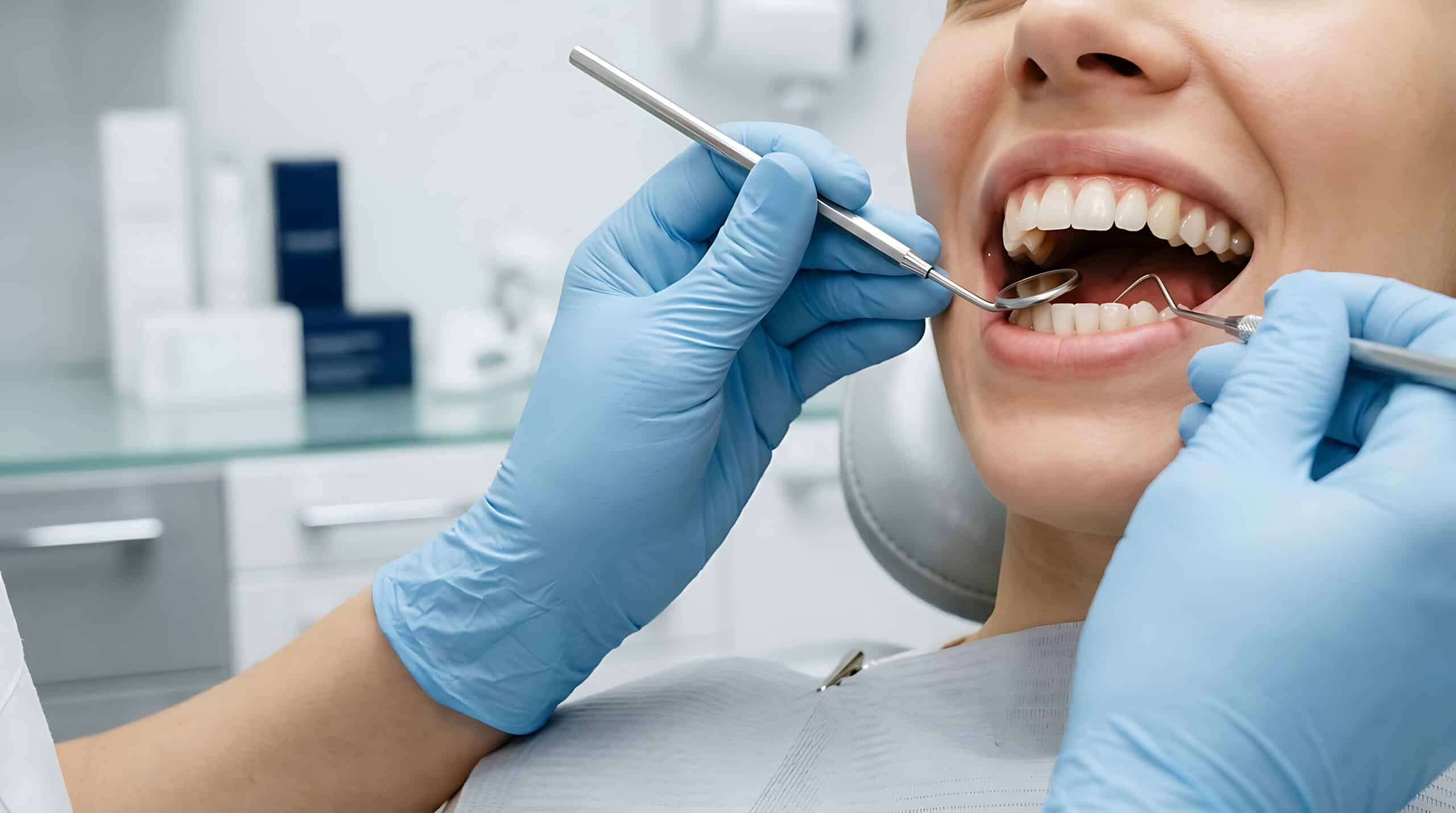 Close-up of a smiling person’s teeth being examined by a dentist using dental tools in a bright, clean examination room Dentistry
